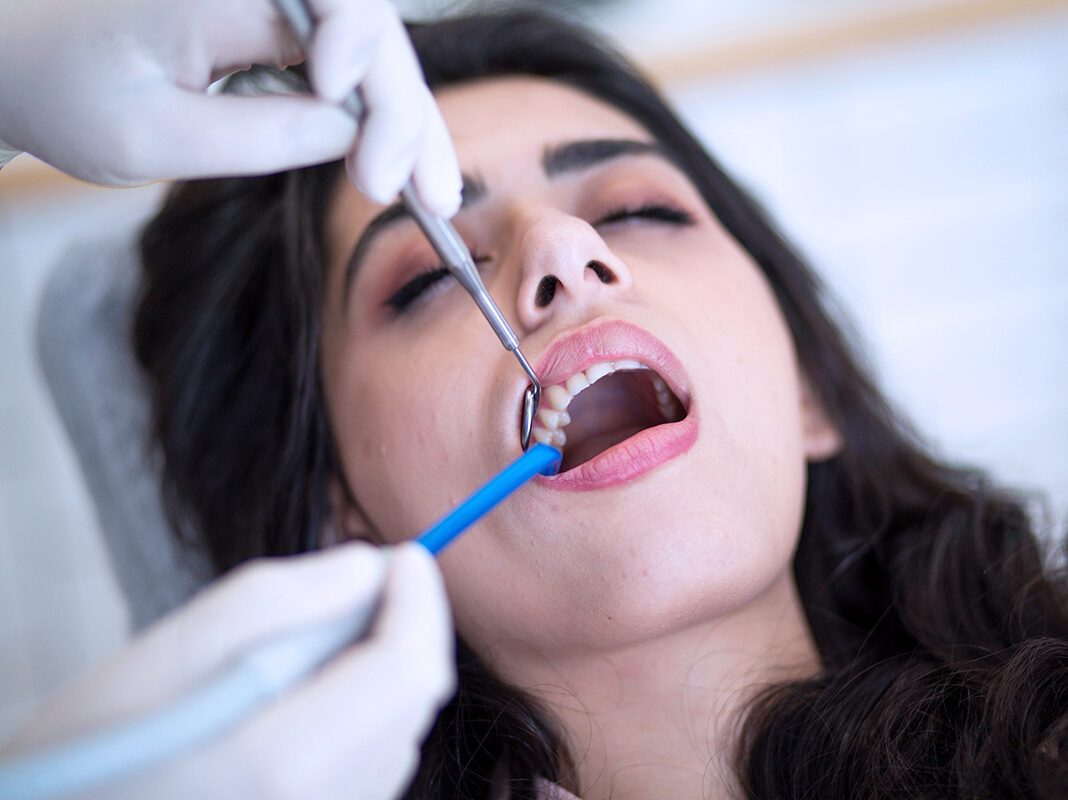 Untersuchung einer Patientin zur Sicherstellung gesunder Zähne